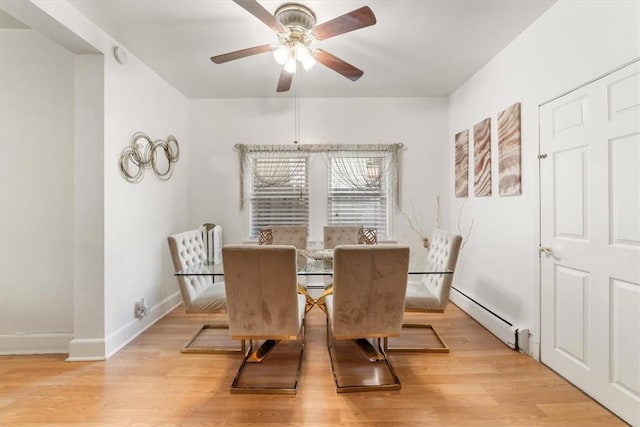 dining area with light hardwood / wood-style flooring, ceiling fan, and a baseboard heating unit