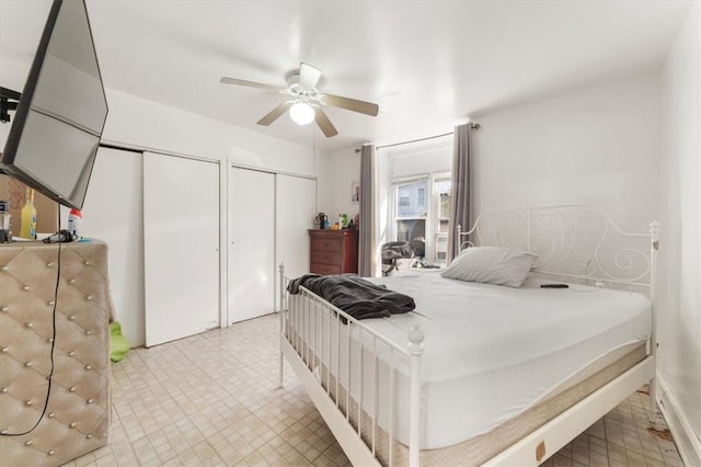 bedroom with ceiling fan and two closets