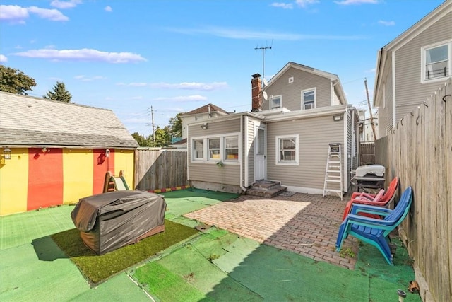 back of house with a yard and a patio