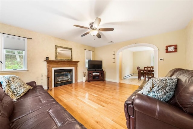 living room with ceiling fan, hardwood / wood-style floors, and a baseboard heating unit