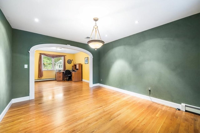 spare room with a baseboard radiator and hardwood / wood-style flooring