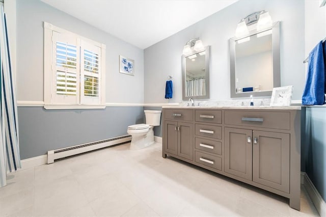 bathroom featuring vanity, toilet, and baseboard heating