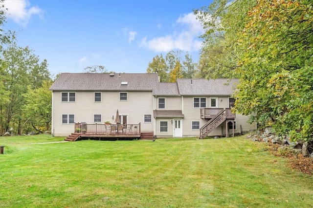 back of house featuring a wooden deck and a lawn