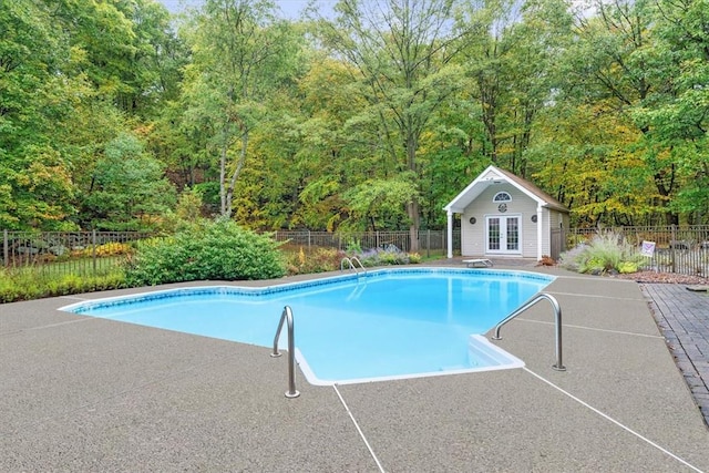 view of swimming pool featuring an outbuilding and a patio