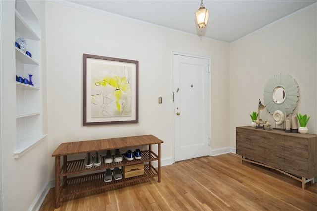 foyer entrance with hardwood / wood-style flooring and crown molding