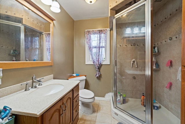 bathroom with tile patterned floors, vanity, a shower stall, and toilet