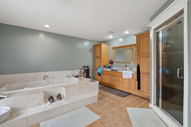 bathroom featuring tile patterned floors, a stall shower, a bath, vanity, and visible vents