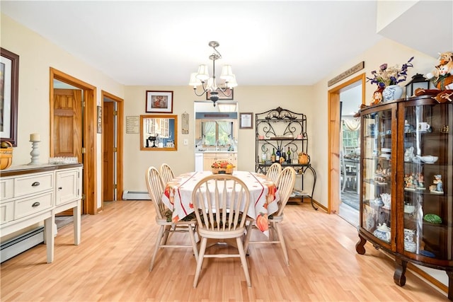 dining area featuring a baseboard radiator, a notable chandelier, and light wood-type flooring