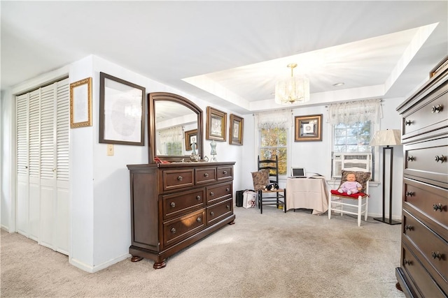 interior space with a tray ceiling, cooling unit, light colored carpet, and a notable chandelier