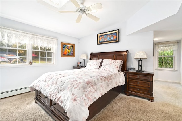 carpeted bedroom featuring ceiling fan and a baseboard heating unit