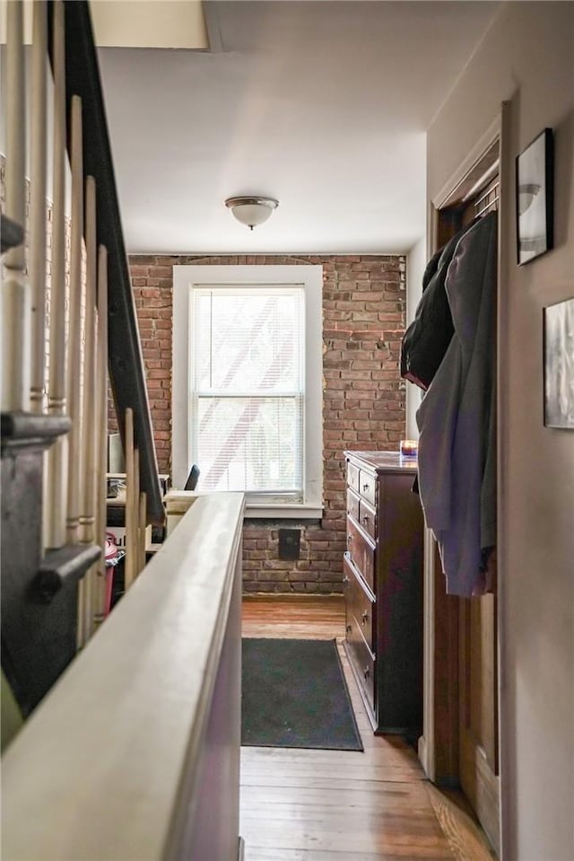 interior space featuring brick wall and light wood-type flooring