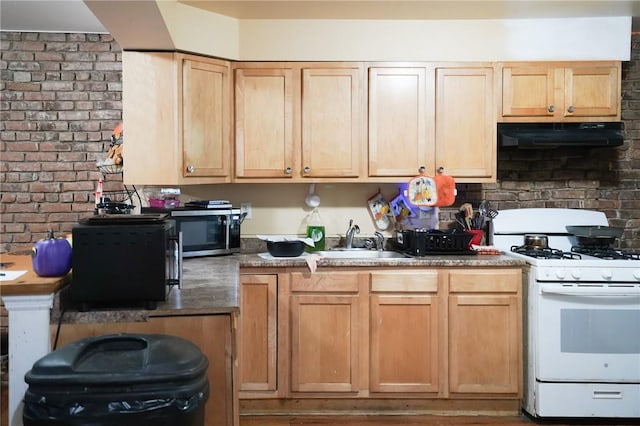 kitchen featuring light brown cabinets, extractor fan, sink, white gas range, and brick wall