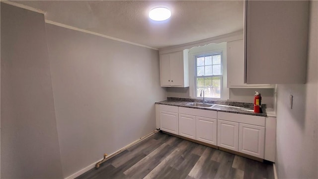 kitchen with a textured ceiling, crown molding, sink, dark hardwood / wood-style floors, and white cabinetry