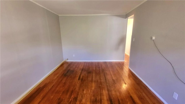 spare room with crown molding and dark hardwood / wood-style floors