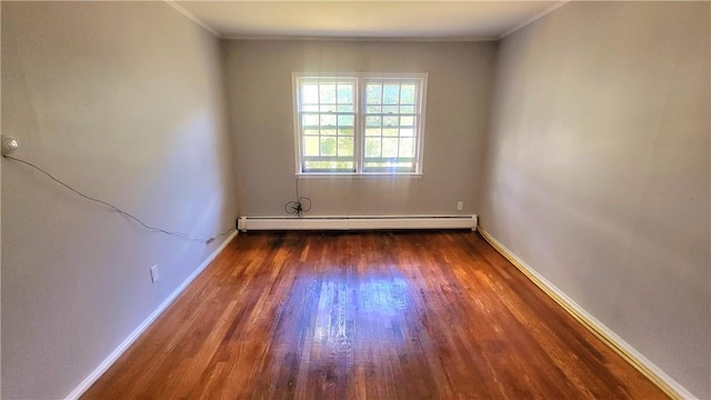 spare room with dark hardwood / wood-style flooring, ornamental molding, and a baseboard heating unit