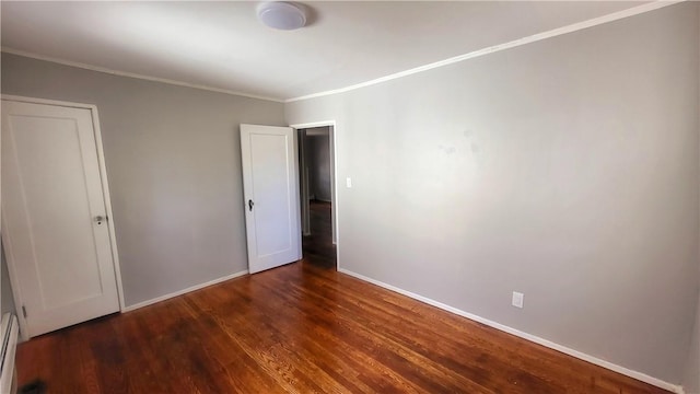 unfurnished bedroom with dark hardwood / wood-style floors, a baseboard radiator, and ornamental molding