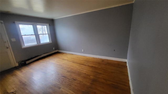 empty room with a baseboard radiator and hardwood / wood-style flooring