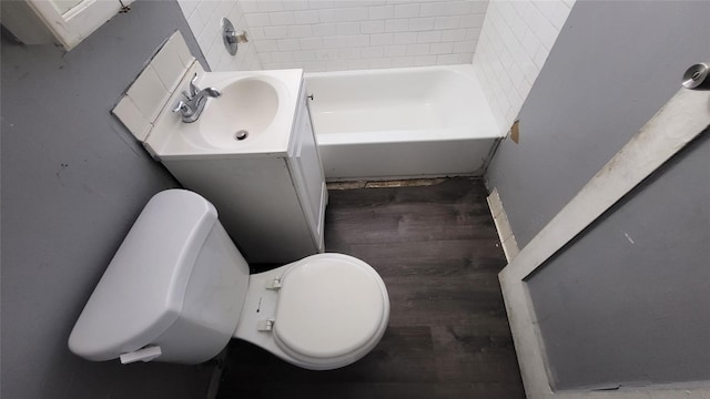 bathroom featuring hardwood / wood-style floors, vanity, a tub to relax in, and toilet