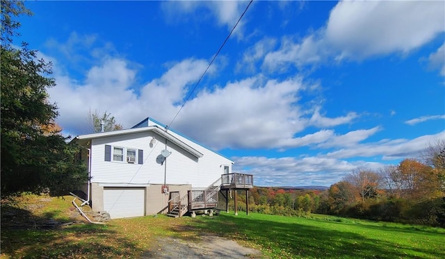 view of side of property featuring a lawn, a deck, and a garage