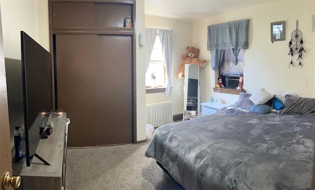 bedroom featuring carpet, radiator heating unit, and a closet