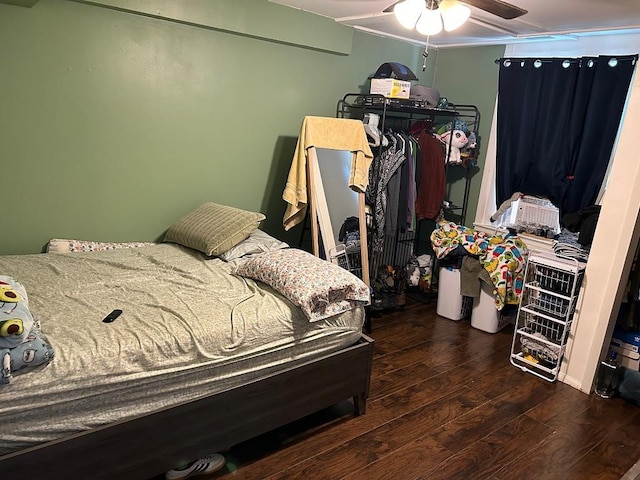 bedroom with dark hardwood / wood-style floors, ceiling fan, and ornamental molding