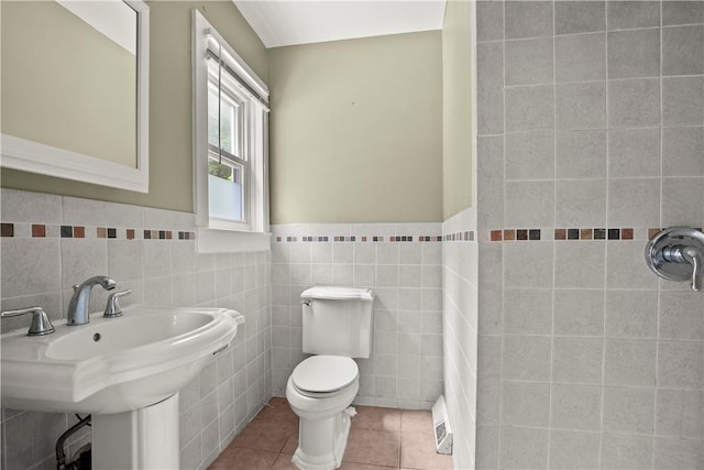 bathroom featuring tile patterned flooring, sink, and tile walls