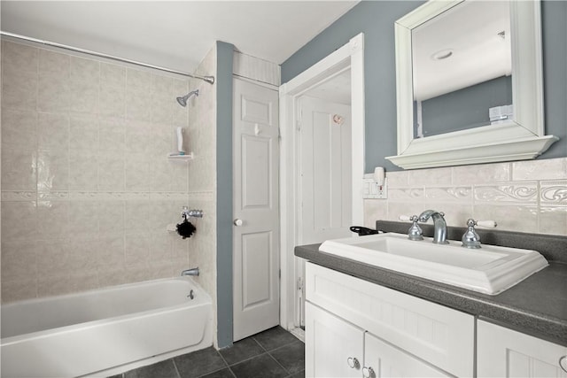 bathroom with vanity, tile patterned floors, tiled shower / bath, decorative backsplash, and tile walls