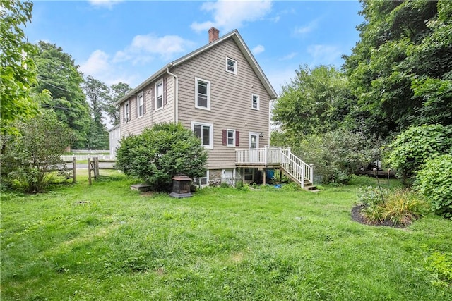 back of property with a lawn and a deck