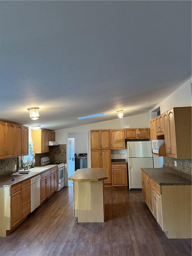 kitchen with dark hardwood / wood-style flooring, lofted ceiling, white appliances, decorative backsplash, and a kitchen island