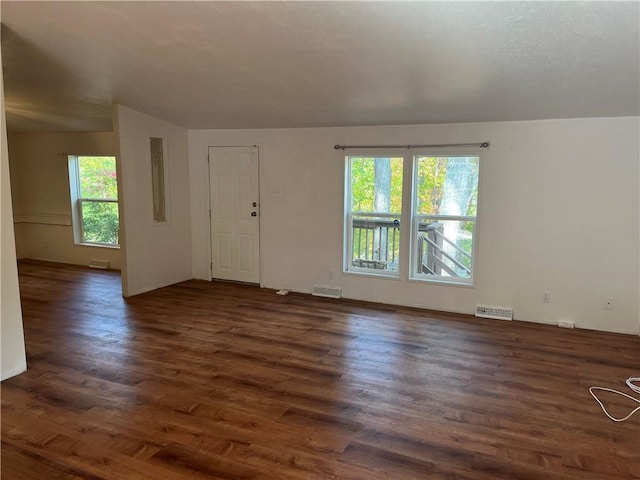 unfurnished room featuring dark hardwood / wood-style flooring and plenty of natural light