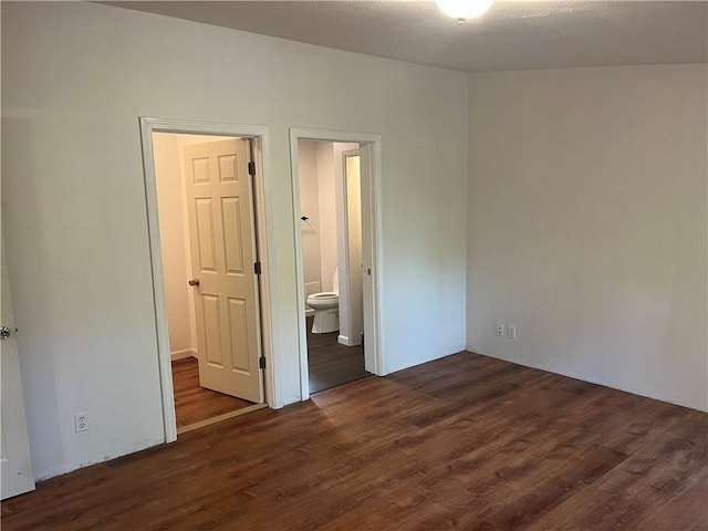 unfurnished bedroom with dark hardwood / wood-style flooring and ensuite bathroom