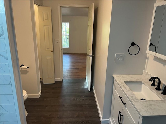 bathroom with hardwood / wood-style floors, vanity, and toilet