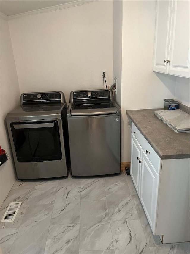 washroom featuring separate washer and dryer, cabinets, and ornamental molding