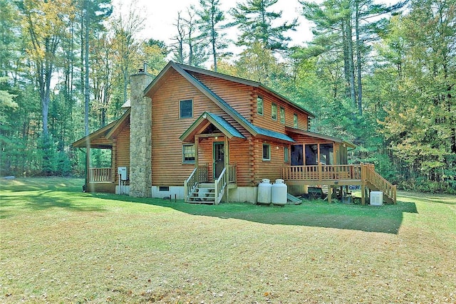 rear view of property featuring a sunroom and a yard