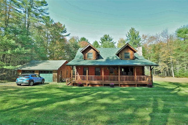 log cabin featuring covered porch, a garage, an outbuilding, and a front lawn