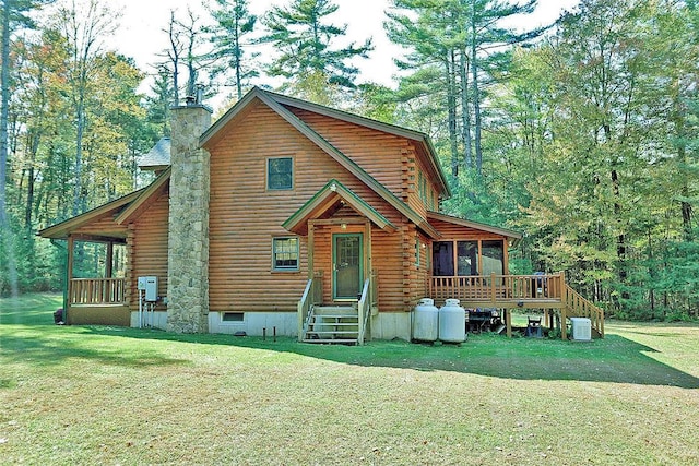 view of front of property with a sunroom, central AC, and a front lawn