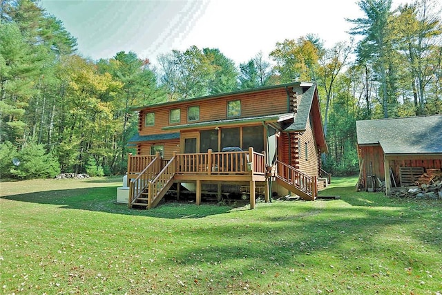 back of property with a sunroom, a wooden deck, and a lawn