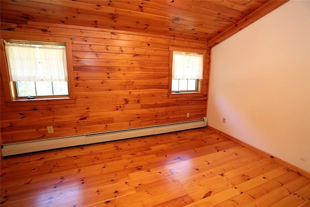 spare room featuring wooden ceiling, wooden walls, a baseboard radiator, and light hardwood / wood-style floors