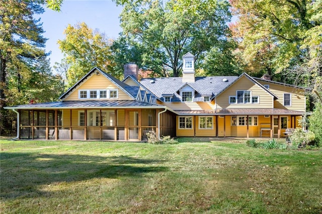 back of property with a sunroom and a yard