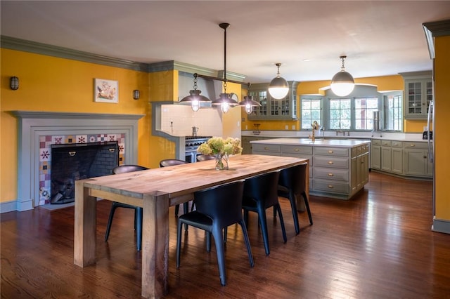 dining area featuring dark hardwood / wood-style flooring, ornamental molding, and a fireplace