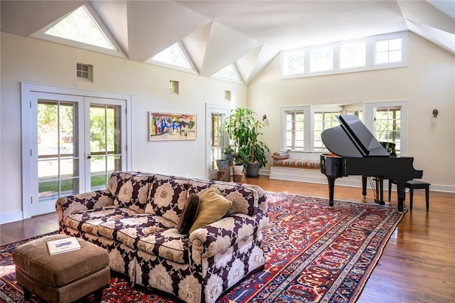 living room featuring hardwood / wood-style flooring, a healthy amount of sunlight, high vaulted ceiling, and french doors