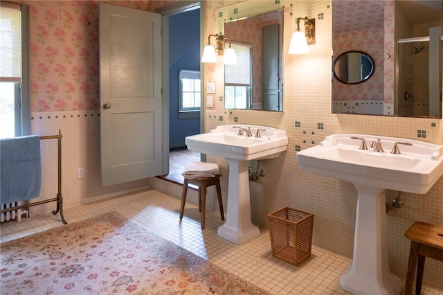 bathroom with a shower, tile patterned flooring, and tile walls