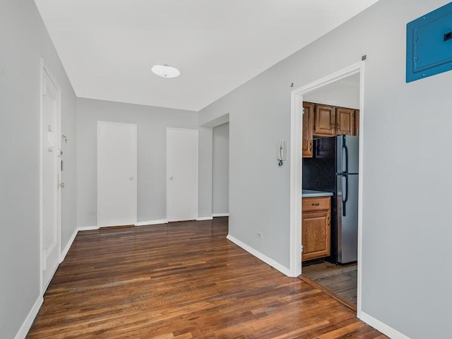 spare room featuring electric panel and dark wood-type flooring