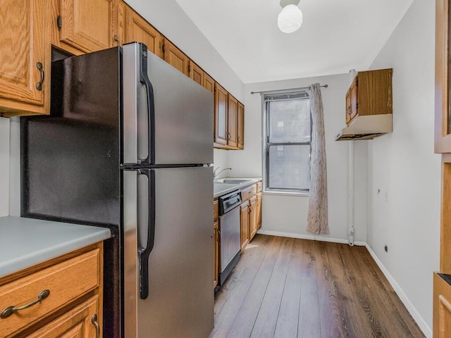 kitchen with stainless steel appliances, dark wood-type flooring, and sink