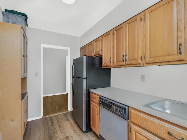 kitchen with light hardwood / wood-style flooring, stainless steel appliances, and sink