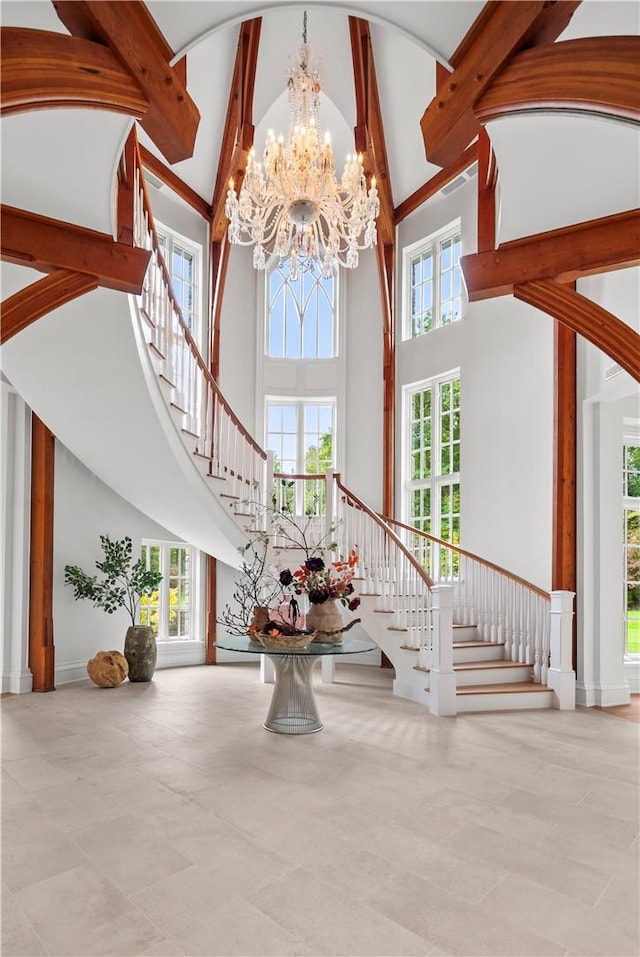 foyer entrance with plenty of natural light, beam ceiling, and high vaulted ceiling