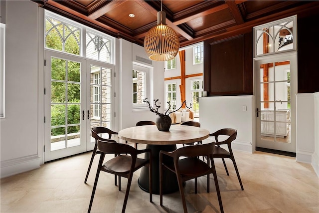 dining room featuring beamed ceiling, a healthy amount of sunlight, ornamental molding, and coffered ceiling