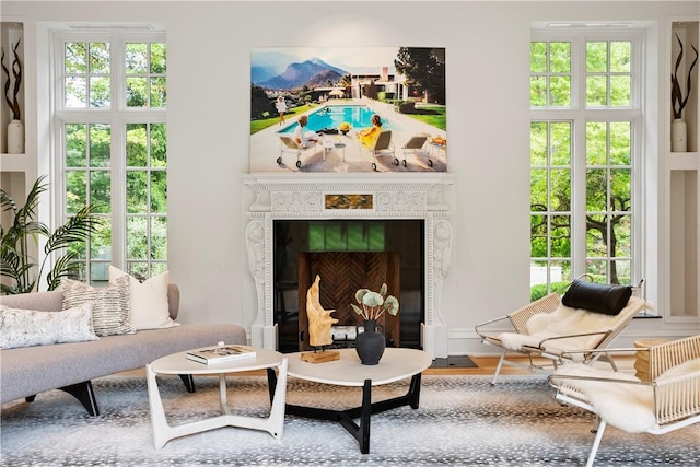 living area with hardwood / wood-style flooring, plenty of natural light, and a fireplace