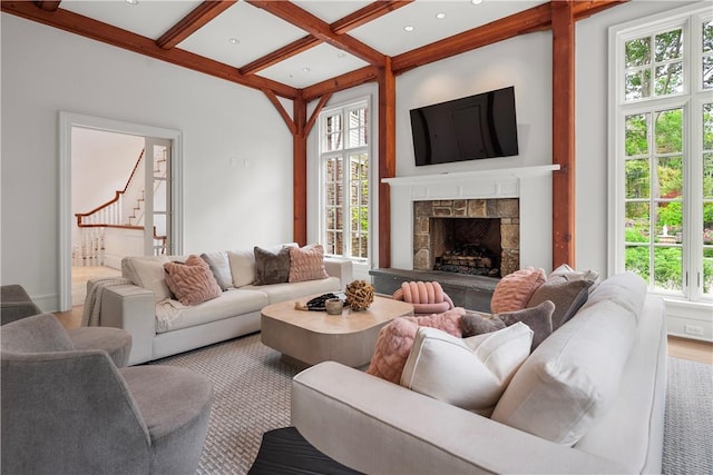 living room featuring a wealth of natural light, a fireplace, and coffered ceiling