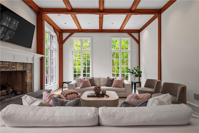 living room featuring a stone fireplace and beamed ceiling